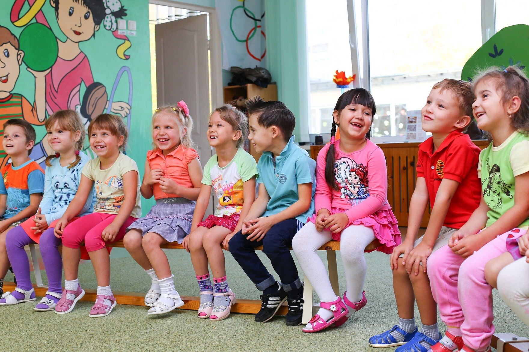 Kindergartenkinder sitzen auf einer Bank