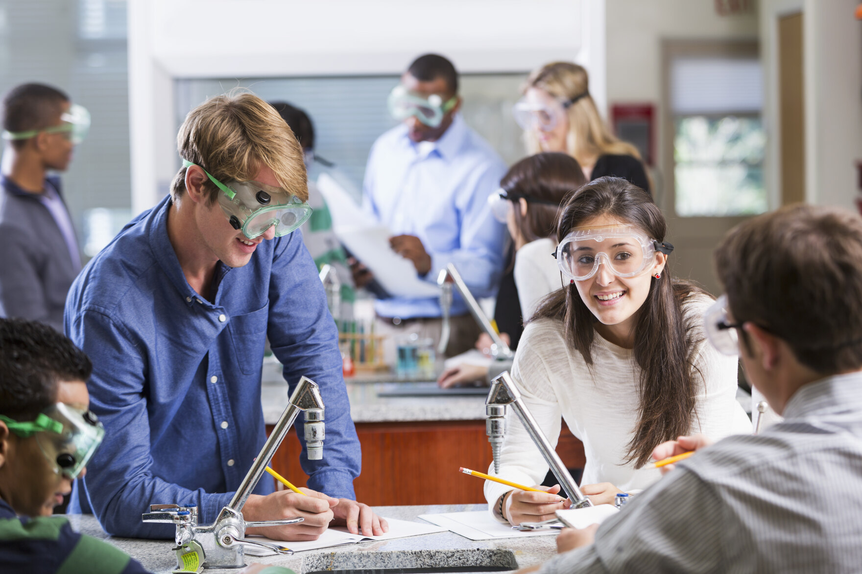 Junge Menschen mit Schutzbrillen in einer Laborsituation